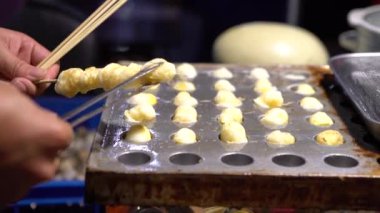 4k Bir Asyalı satıcı lezzetli bir kızarmış bıldırcın yumurtası hazırlar. Taipei 'deki Asia Night Market' in popüler yerel yemekleri. Tayvan-Dan