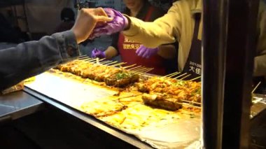 Taipei, Tayvan-26 Şubat, 2018: 4K, yol kenarındaki tezgahlarda leş gibi tofu pişiren tedarikçi. Tayvan usulü mayalanmış tofu ve güçlü bir koku. Gece marketlerinde abur cubur olarak satılıyor. Popüler Asya yemekleri: Dan
