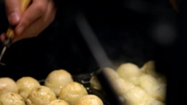 Slow Motion Japon satıcı sıcak tava Japonya üzerine bir Takoyaki hazırlayın. Yerel sokak yemeklerinde ahtapotla popüler kızarmış topları pişirme işlemi. Asya 'da gece pazarında top şeklinde yemek yapmak.