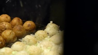 Slow Motion Asyalı satıcı lezzetli bir Takoyaki hazırla. Buğday unlu hamur hamuru hamurundan yapılmış popüler Top şeklinde Japon aperatifini pişirme ve özel kalıplı tavada pişirme işlemi