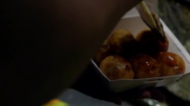 Slow Motion Asyalı satıcı lezzetli bir Takoyaki hazırla. Aşçı kızarmış toplara ahtapot ile tatlı sos koyar. Japon aperatifi un bazlı hamur köftesi kızartılmış hamur Dan.