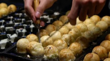 Slow Motion Japon satıcı sıcak tava Japonya üzerine bir Takoyaki hazırlayın. Yerel sokak yemeklerinde ahtapotla popüler kızarmış topları pişirme işlemi. Asya 'da gece pazarında top şeklinde yemek yapmak.