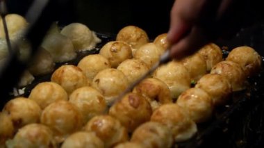Slow Motion Asyalı satıcı lezzetli bir Takoyaki hazırla. Buğday unlu hamur hamuru hamurundan yapılmış popüler Top şeklinde Japon aperatifini pişirme ve özel kalıplı tavada pişirme işlemi