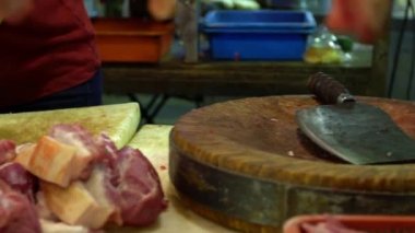 Yerel gıda caddesi geleneksel Taipei 'de et kesme tahtasının üzerinde çiğ et kesmek için bıçak kullanan domuz dükkânı sahibinin yavaş hareket eden elleri. Ünlü pazar yeri Tayvan-Dan