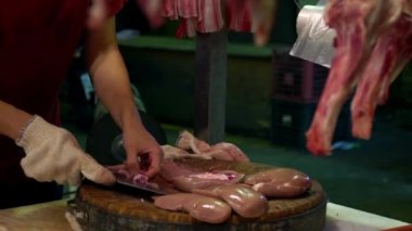 Domuz dükkânı sahibinin Asyalı ellerinin yavaş hareket etmesi, yerel gıda caddesi geleneksel Taipei pazarında çiğ böbrek organını dilimlemek için bıçak kullanıyor. Ünlü pazar yeri Tayvan-Dan