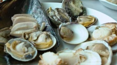 Jagalchi Balık Pazarı 'ndaki Deniz Ürünleri Marketi' nin yanındaki Güney Kore Restoranının Yavaş Çekim Tabağı. Asyalı kadın Busan, Güney Kore 'de öğle yemeği yiyor. İstiridye yiyorum.
