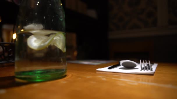 웨이터가 식탁에 레몬을 곁들인 물컵을 레스토랑에 내놓았다 — 비디오