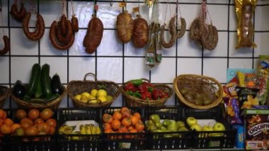 Extremadura, İspanya-08 Aralık 2017: 4K, İspanyol geleneksel sosisleri ve sebzeleri kasap dükkanında. Çeşitli meyveler ve markette asılı kurutulmuş et. İberya domuz eti süpermarketi Dan