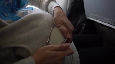 4K, Asyalı hamile kadın uçağın içinde emniyet kemerini bağlıyor. Kalkışı beklerken uçakta emniyet kemeri takan yolcular. Yolculuk sırasında güvenli yolculuk önemlidir, Dan.