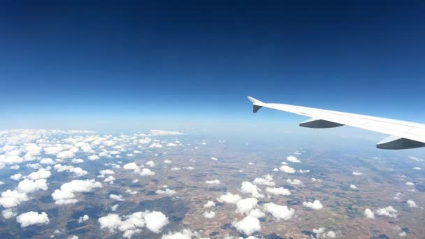 上から美しいヨーロッパの国は 飛行機の窓を通して見られるように 乗客のハメが空路で移動 青い空と雲との飛行旅行で飛行機の翼でキャビン内の旅行者のビュー — ストック動画