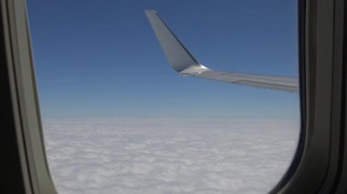 4K hava yoluyla seyahat ediyor. Gökyüzünün muhteşem manzarası ve yukarıdan görünen bulutlar, bir uçak penceresinden, uçak kanadından, Hd Ultra-Dan