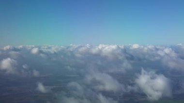 4K, güzel Avrupa ülkesi, uçak penceresinden görüldüğü gibi. Yolcu kabini hava yoluyla seyahat ediyor. Mavi gökyüzü ve bulutlarla dolu bir uçuşta kamarada, uçak kanadında bir gezginin görüntüsü. - Dan.