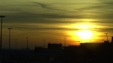Amsterdam Schiphol Uluslararası Havaalanı 'nda Sunset View yavaş çekim yapıyor. Gündoğumunda turuncu gökyüzü olan modern terminalde uçak bekliyor. Avrupa havaalanları - Dan