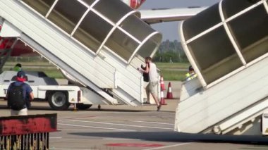 Siem Reap, Kamboçya-20 Nisan 2018: 4K Kamboçya 'da güneşli bir günde Siem Reap Uluslararası Havalimanı' nın dışındaki düşük maliyetli uçağa binen insanlar. Gezginler açık havada sıcak hava Dan