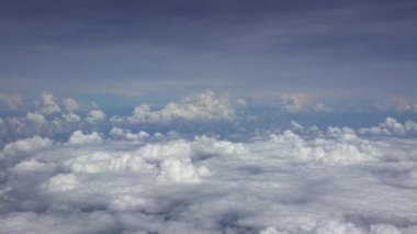 4K hava yoluyla seyahat ediyor. Gökyüzünün muhteşem manzarası ve yukarıdan bulutlar, bir uçak penceresinden görüldüğü gibi. Uçak yolculuğunda ve güzel manzaralı kamaradaki gezginin perspektifinden