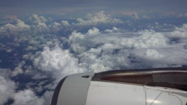 4K hava yoluyla seyahat ediyor. Türbin uçağı güzel gökyüzü ile uçuyor. Yukarıdan güzel bulutlar, uçak penceresinden görüldüğü gibi. Kanatların ucu kırmızı. Kamaradaki gezginin görüntüsü - Dan