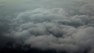 4K hava yoluyla seyahat ediyor. Kara gökyüzü fırtına bulutlarının görüntüsü bir uçak penceresinden görüldüğü gibi yukarıdan hareket ediyor.