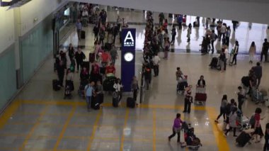Hong Kong-04 Nisan 2017: 4K Hava Görüntüsü Hong Kong Uluslararası Havaalanı 'nın Gelen Salonu' nda Yürüyen Gezginler Kalabalığı. İş ya da turizm için bavulla seyahat eden insanlar.
