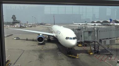 Hong Kong-03 Nisan 2016: 4k güzel Asyalı kadın Hong Kong havaalanında uçağa bakıyor. Çin-Dan havaalanı terminalinde yürüyen gezginler.