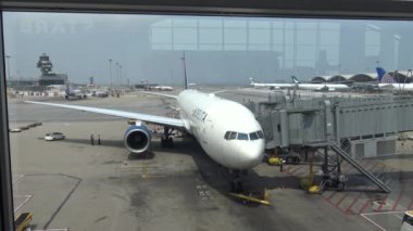 Hong Kong-03 Nisan 2016: 4k güzel Asyalı kadın Hong Kong havaalanında uçağa bakıyor. Çin-Dan havaalanı terminalinde yürüyen gezginler.