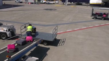 Bari, İtalya-24 Eylül 2018: 4K, Havaalanı personeli bavulları uçağa yüklüyor. Taşıyıcı bant uçağının bagajı. Kalkış terminalinde yolcu bavullarını düzenleyen bir işçi.