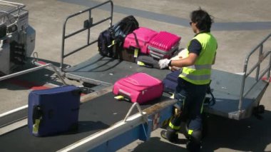 Bari, İtalya-24 Eylül 2018: Havaalanı personelinin bavullarını bir uçağın içine yüklemesi. Taşıyıcı bant uçağının bagajı. Kalkış terminalinde yolcu bavullarını düzenleyen bir işçi.