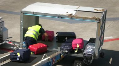 Bari, İtalya-24 Eylül 2018: Havaalanı personelinin bavullarını bir uçağın içine yüklemesi. Taşıyıcı bant uçağının bagajı. Kalkış terminalinde yolcu bavullarını düzenleyen bir işçi.