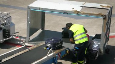 Bari, İtalya-24 Eylül 2018: Havaalanı personelinin bavullarını bir uçağın içine yüklemesi. Taşıyıcı bant uçağının bagajı. Kalkış terminalinde yolcu bavullarını düzenleyen bir işçi.