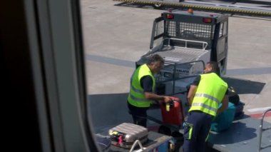 Bari, İtalya-24 Eylül 2018: Slow Motion havaalanı personeli uçak penceresinden görüldüğü üzere bagajları bir uçağın içine yüklüyor. Taşıyıcı bant uçaklarının bagajları. Yolcu bavullarının düzenlenmesi - Dan
