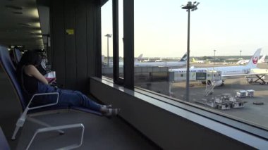Japonya-07 Temmuz 2017: 4K Havaalanında Bekleyen Kadın, Tokio Uluslararası Havaalanı Havaalanı Terminallerinde Uçak Arkaplanı.