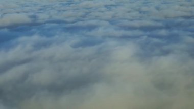 Hava yoluyla seyahat etmek. Gökyüzü ve bulutların yukarıdan görünüşü, bir uçak penceresinden görüldüğü gibi - Dan