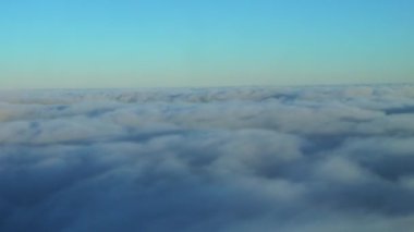 Hava yoluyla seyahat etmek. Gökyüzü ve bulutların yukarıdan görünüşü, bir uçak penceresinden görüldüğü gibi - Dan