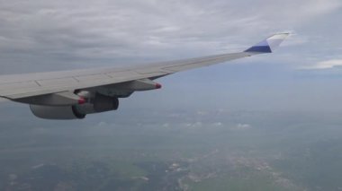 4K hava yoluyla seyahat ediyor. Japonya Adası 'ndaki bir şehrin havadan görünüşü, Uçuş Dan sırasında bir uçak penceresinden görülen uçağın ve arka plandaki dağın kanadına bakın.