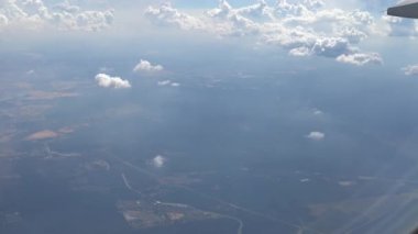 4K Hd Ultra, hava yoluyla seyahat ediyor. Gökyüzünün ve bulutların muhteşem manzarası, bir uçak penceresinden görüldüğü gibi, yeryüzü ve okyanusu bulutlarla görüyor - Dan