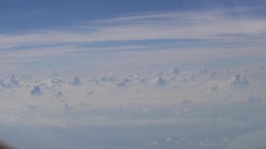 4K Hd Ultra, hava yoluyla seyahat ediyor. Gökyüzü ve bulutların muhteşem manzarası, yukarıdaki güneş ışığı, bir uçak penceresinden görülebildiği gibi - Dan