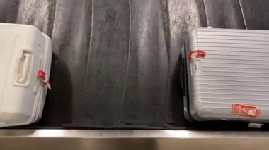 Taipei, Tayvan-17 Ocak 2020: 4k, Uluslararası havaalanında bagaj teslim talebi. Varış bölgesindeki yolcu terminalindeki bagaj taşıyıcı bandında çeşitli bavullar hareket ediyor. Bavul ve bagaj seyahat ediyor.