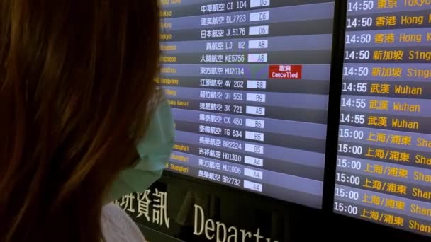 Chinoise Regardant Tableau Aéroport Avec Des Avions Annulés Pour Wuhan — Video