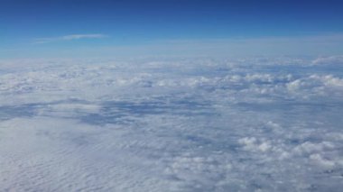 4K, gökyüzü ve bulutların muhteşem manzarası yukarıdaki güneş ışığı, uçak penceresinden görüldüğü gibi. Yolcu aracının hava yoluyla seyahat edişinin güzel manzarası. Uçak-Dan 'deki kamarada gezgin.
