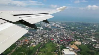 Tayvan şehrinin yukarıdan görünüşü bir uçak penceresinden görüldüğü gibi bir uçağın kanatları altında, hava yoluyla seyahat ediyor. - Dan.