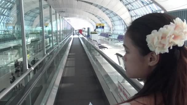 2016年4月9日 頭の中に花を持つ4Kの美しいアジアの女性がタイのスワンナプーム空港に到着しました バンコク ダンの空港ターミナル内を歩く旅行者 — ストック動画