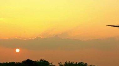 Gün batımında yavaş çekim uçuşu. Bir Ticari Yolcu Uçağı Tepenin Üzerinde Uçuyor. Jet uçağı ya iniş yapacak ya da ulusal havaalanına park edecek. 120 fps-Dan hızında ağır çekim.