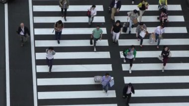 Hava manzarası, kalabalık insanlar ve Tokyo İstasyonu caddesinde kalabalık kavşaklarda yürüyen turistler. Japonya şehir merkezindeki Marunouchi 'de trafik ışığı işareti olan tren istasyonu alanı.