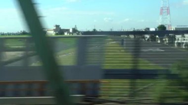 Japonya 'da güzel bir günde Tokyo' da tren yolculuğunun penceresinden 4K manzarası. Trenler bir tren istasyonundan şehrin üzerinden geçiyor. - Dan.