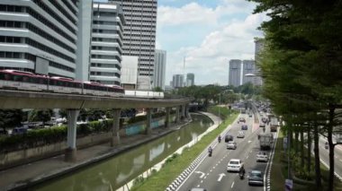 Kuala Lumpur, Malezya-13 Nisan 2018: 4K, Yükseltilmiş tren, dış gün caddelerde trafik arabalarının bulunduğu bir hat üzerinde seyahat ediyor. Modern metro sistemine sahip şehir manzarası. Metro şehri gezisi.