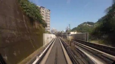 Zaman atlaması. Yükseltilmiş bir tren, modern sürücüsüz Tayvan 'da yolculuk. Taipei şehri boyunca uzanan yüksek raylı metro sistemi. Taipei 101 kulesine bakın ve bir tünelden geçin.