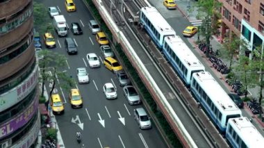 Taipei, Tayvan-26 Mart 2016: 4K Hava sahası yükseltilmiş tren, Taipei Asya şehrinde trafik arabaları ve sokaktaki insanlarla dolu bir hat üzerinde seyahat ediyor. Şehir manzarası modern metro sistemi istasyon Dan 'e varıyor.