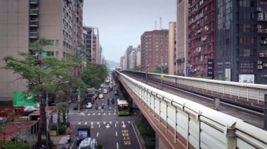 Taipei, Tayvan-26 Mart 2016: 4K Yükseltilmiş Tren, Taipei Asya şehrindeki caddelerde trafik arabalarıyla bir hat üzerinde seyahat ediyor. Modern Metro sistemine sahip şehir manzarası Tayvan-Dan istasyonuna ulaşıyor.