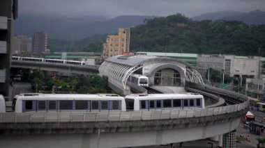 Taipei, Tayvan-26 Nisan 2019: 4K, gün batımında yoldan geçen yükseltilmiş tren. Modern metro sistemi ve güzel güneş ışığıyla muhteşem bir şehir manzarası. MRT 'nin şehir çevresindeki seyahatinin üst hava görüntüsü