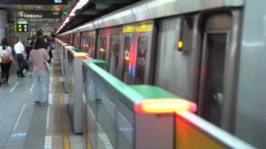 Taipei, Tayvan-29 Ağustos 2017: 4K Asyalılar Taipei 'deki metro istasyonunda trene binmek için yürüyorlar. Modern metro sistemi Tayvan 'daki istasyona varıyor. Tren geliyor ve insanlar Dan 'e biniyor.