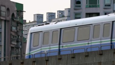 Yükseltilmiş trenin yavaşça yoldan geçmesi. Modern metro sistemiyle muhteşem bir şehir manzarası. MRT şehri dolaşmanın en iyi yollarından biridir. Taipei, Asya 'nın popüler bir turizm merkezidir.